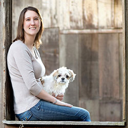 Meredith Stepita holding a white small dog on her lap