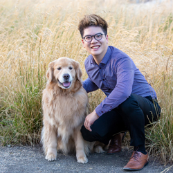 Dr. Wayne Tsang with his Golden Retriever sitting in a field