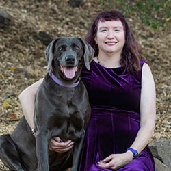 Dr. Julie Damron sitting with her gray dog